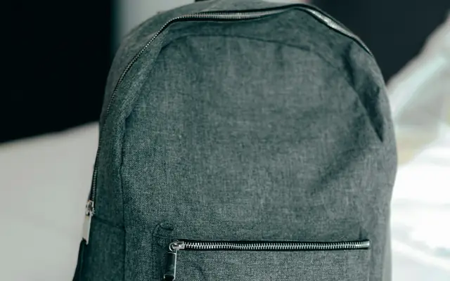Mochila escolar sobre una cama: abogado penalista para menores de edad