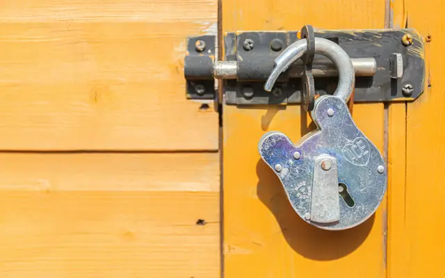 Candado abierto en una puerta de madera: abogado por robo y hurto