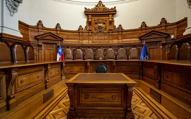 Sala de audiencias de un tribunal en Chile, con estrados de madera y banderas
